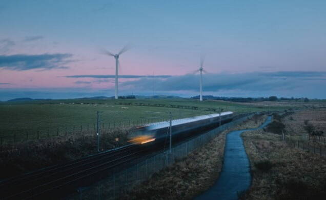 Train running through windmill farm 